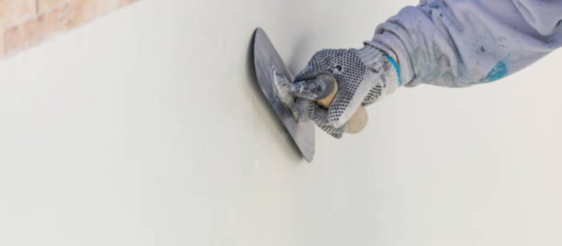 Worker Smoothing Wet Pool Plaster With Trowel.